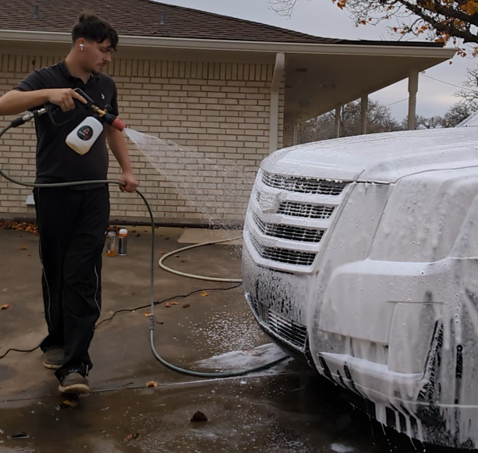 Ace of Hearts Detailing detailer foam-washing an SUV in a driveway